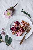 Belgian spelt waffles with warm cherries, cranberries, pomegranate seeds and Christmas roses