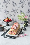 Erdbeer-Mandel-Biskuitrolle mit Rosenwasser, Mascarponecreme, Pistazien, kandierten Rosenblütenblättern und Blumen