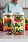 Layered salad in glass with spinach, beans, cheese and egg