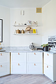 Lederschlaufen als Griffe an den Küchenfronten mit Marmorplatte