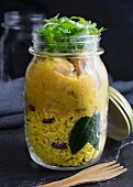 Cremiges Hähnchencurry im Glas mit Kurkuma, Kokos, Zimt und Rosinenreis, garniert mit Koriandergrün (Malaysia)