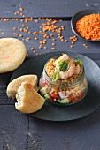 Avocado salsa with lentils and shrimps in a glass jar