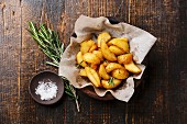 Fried Country-style Potato wedges and salt on wooden background