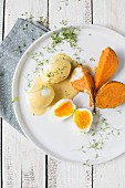 Eggs in mustard sauce with sweet potatoes and cress