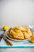 A stack of panakes with lemon curd and fresh lemon slices