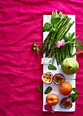 An arrangement of asparagus, sugar snap peas and fruits
