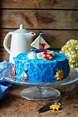 A children's cake decorated with a sailing boat and a bear