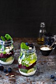Vegetable salads with berries and yoghurt dressing in glass jars