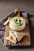 Classic hummus with herbs, olive oil in a glass jar and lavash, Traditional Middle Eastern cuisine
