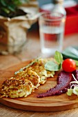 Potato and vegetable fritters on a wooden chopping board