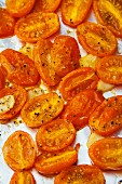 Roasted orange grape tomatoes and garlic on a roasting pan
