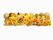 Yellow fruit and vegetables in front of a white background