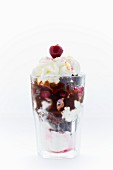 Frozen yoghurt with chocolate cake, cherries, chocolate sauce and cream