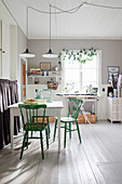 Green chairs at table in sewing room with classic wall coverings