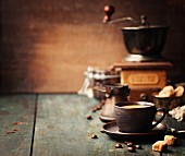 Kaffeestilleben (Tasse Kaffee, Kaffeebohnen, Zucker und Vintage-Kaffeemühle)