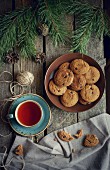 Cookies and tea on wooden table with pine cones