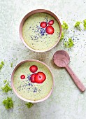 Green smoothie bowls with spinach, pineapple, strawberries and poppy seeds