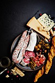 Gemischter Antipastiteller mit Oliven, Kapern, Prosciutto, luftgetrockneten Würsten, Salami, Grissini, Parmesan und Blauschimmelkäse