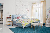 Gepolstertes Doppelbett mit Kleiderbank auf türkisfarbenem Teppich in hellem Schlafzimmer