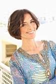 Brunette woman wearing patterned, embroidered tunic