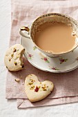 Cookies with pistachios and dried rose petals, served with a cup of coffee