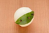 An onion garnished with a bay leaf and cloves