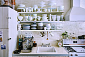 Voll beladenes Geschirrregal über Spülbecken in Vintage Küche
