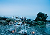 Candle lantern, lounger and cushions for romantic picnic by the sea