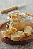 Foie gras in a glass jar with baguette slices