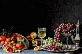Obststillleben im Stil eines Gemäldes mit Zitrusfrüchten, Trauben und Wein