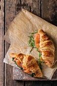 Two croissant with smoked salted salmon, spinach and arugula
