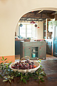 Bowl of grapes on table in front of open doorway leading into kitchen