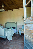View through open wooden door into Mediterranean bedroom