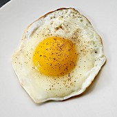 Fried egg on white plate from above