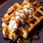 Belgian waffle with whipped cream, almonds and carmel sauce