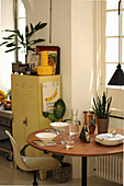 Set round table and metal locker next to window in kitchen