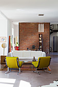 Yellow easy chairs and white sofa in open-plan loft interior