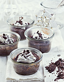 Chocolate cake in glass ramekins with cream (Christmas)