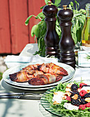Grilled duck breast wrapped in bacon with a summer salad