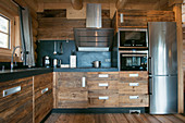 Moderne Küche mit rustikalen Holzfronten und Edelstahlkühlschrank