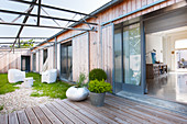 Modernes Holzhaus um Terrasse und Innenhof mit Sitzplatz