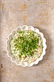 Mayonnaise dip with olives and herbs in a small bowl on a stone background