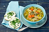 Minestrone with leeks and beans, with bread rolls topped with fresh cheese