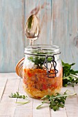 A lentil curry with couscous, sheep's cheese and rocket in a glass jar