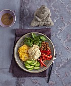 A Buddha bowl with millet, red pepper, avocado and orange