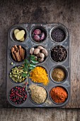Various spices arranged in a muffin tin