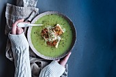 A woman's hands holding a bowl of creamy leek soup