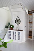 Glass-fronted cabinet in rustic wood-panelled hallway