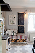 Chalkboards above bench with firewood below in country-house kitchen