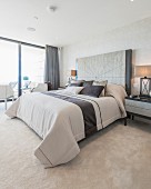 Elegant bedroom in shades of beige with glass wall